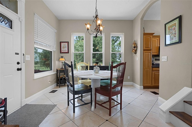 tiled dining space featuring an inviting chandelier