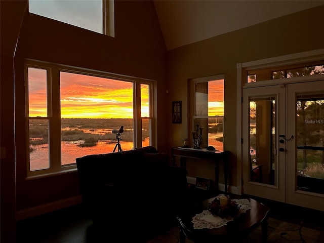 interior space featuring vaulted ceiling, french doors, and a water view