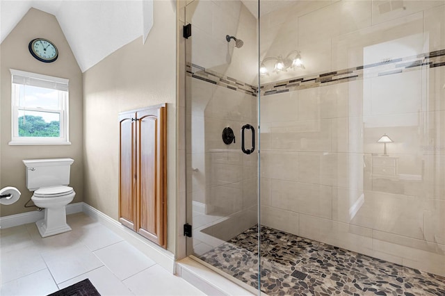 bathroom with tile patterned flooring, vaulted ceiling, toilet, and walk in shower