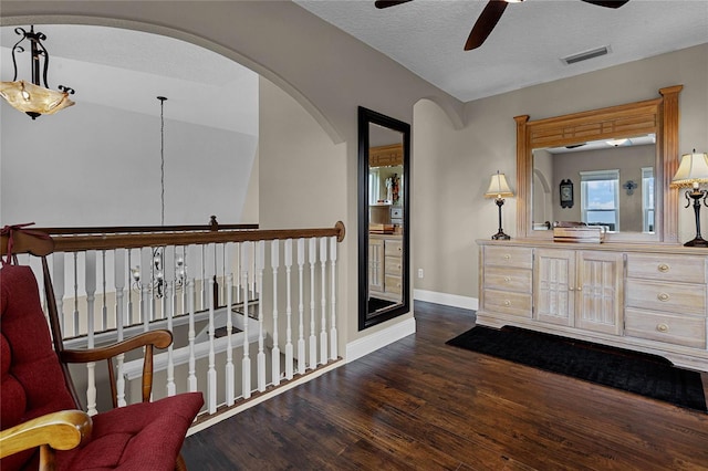 interior space with a textured ceiling, ceiling fan, and hardwood / wood-style floors