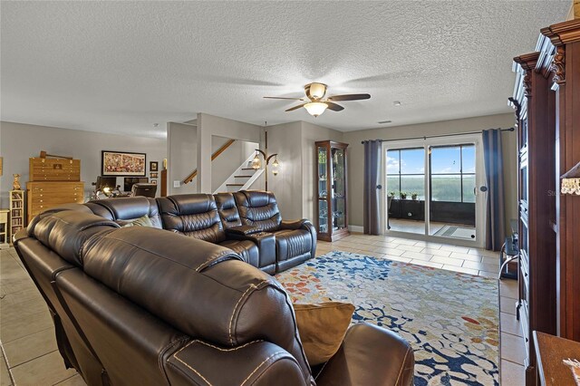 tiled living room with ceiling fan and a textured ceiling