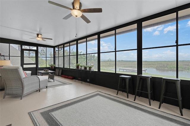 sunroom with a water view, ceiling fan, and plenty of natural light