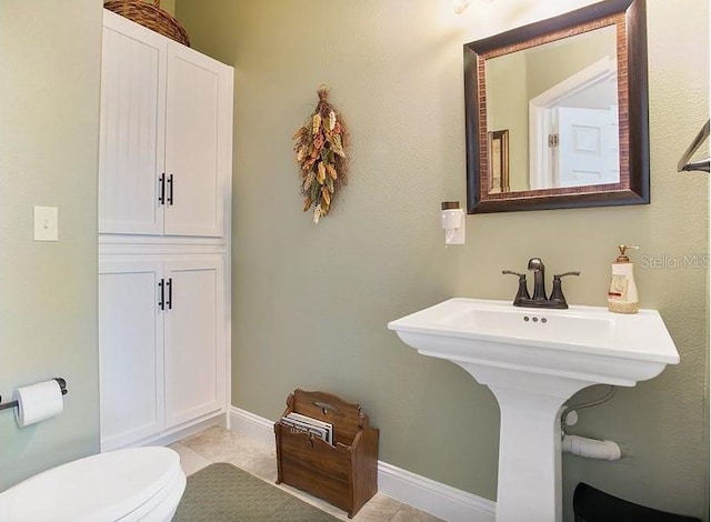 bathroom featuring tile floors and toilet