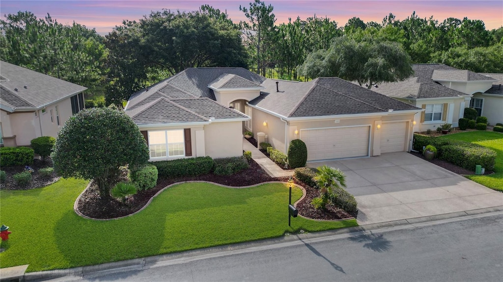 view of front of property with a garage and a yard