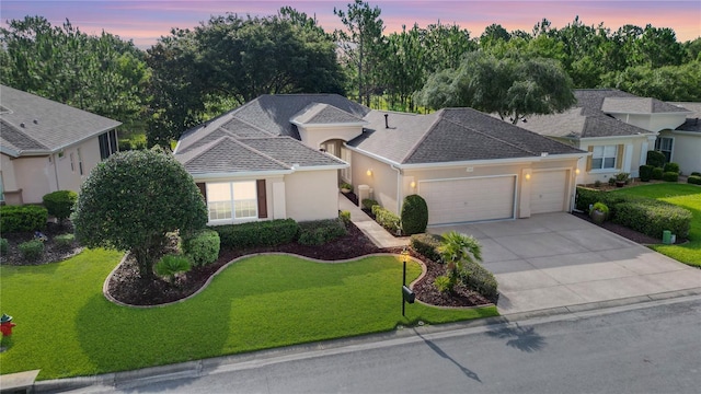 view of front of property with a garage and a yard