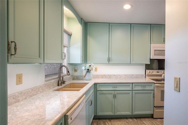 kitchen featuring white appliances, green cabinets, and sink