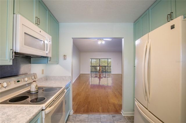 kitchen featuring ceiling fan, green cabinets, and white appliances