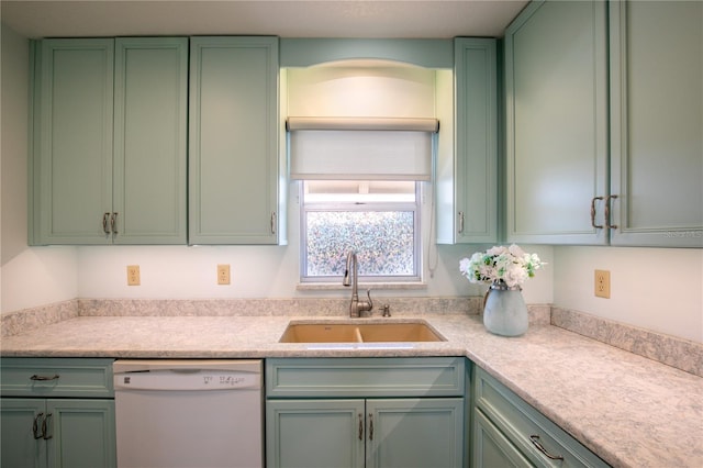 kitchen with green cabinetry, white dishwasher, and sink