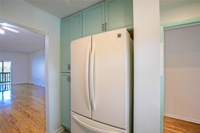 kitchen featuring white fridge, green cabinets, ceiling fan, and light hardwood / wood-style flooring