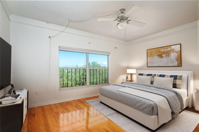 bedroom featuring crown molding, ceiling fan, hardwood / wood-style floors, and a textured ceiling