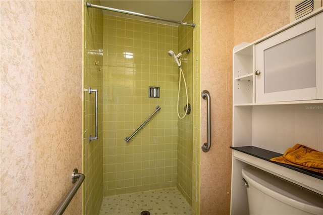 bathroom featuring toilet and tiled shower