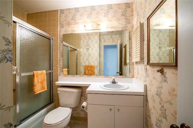 full bathroom featuring enclosed tub / shower combo, vanity, and toilet