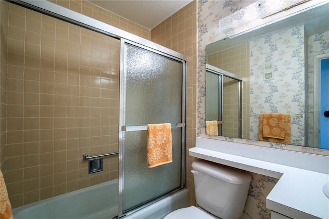 full bathroom featuring toilet, vanity, and bath / shower combo with glass door