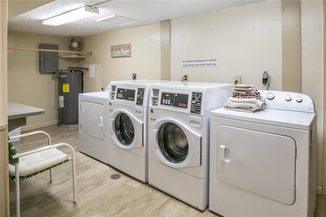 laundry area with washing machine and dryer, electric water heater, electric panel, and light wood-type flooring