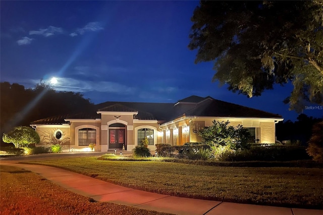 view of front of property with a yard and french doors