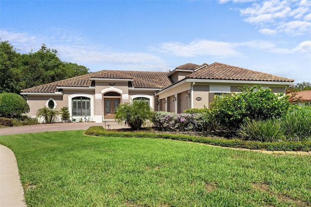 mediterranean / spanish home with a garage and a front yard