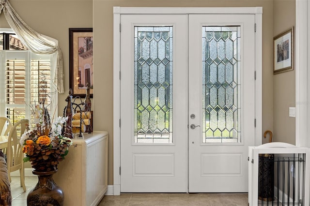 foyer entrance with light tile patterned floors and french doors