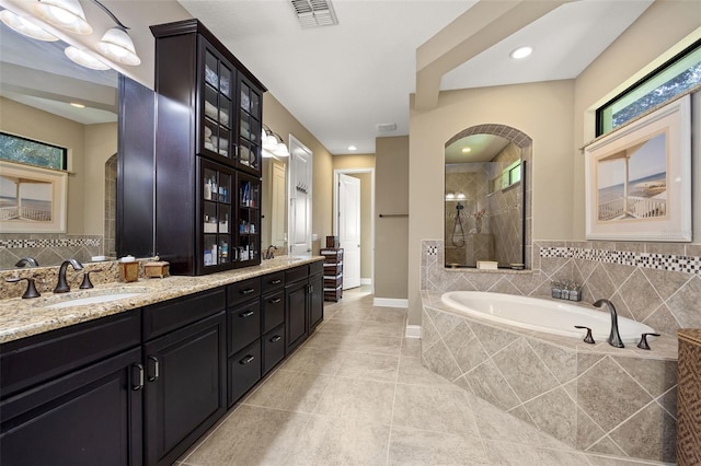 bathroom featuring vanity, plus walk in shower, and tile patterned flooring