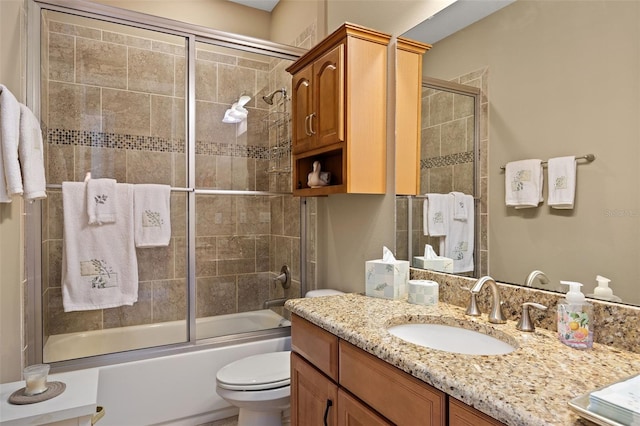 full bathroom featuring bath / shower combo with glass door, vanity, and toilet