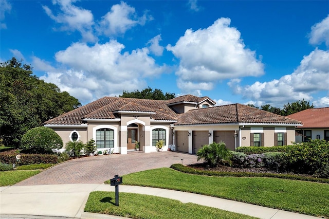 mediterranean / spanish-style home featuring a garage and a front lawn