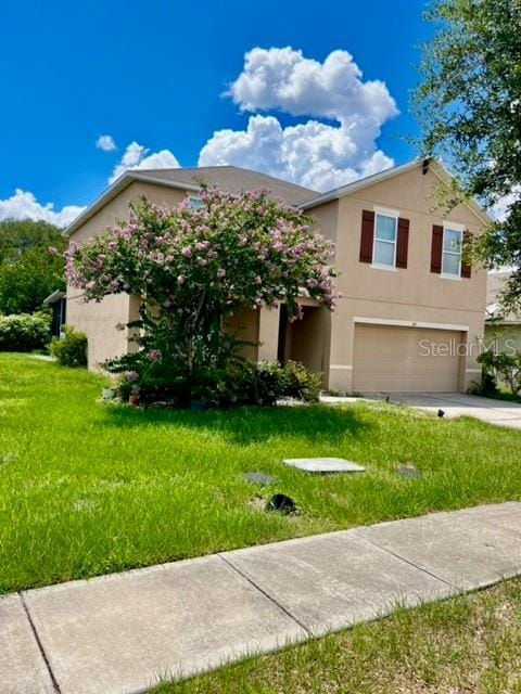 view of front of property featuring a garage and a front lawn