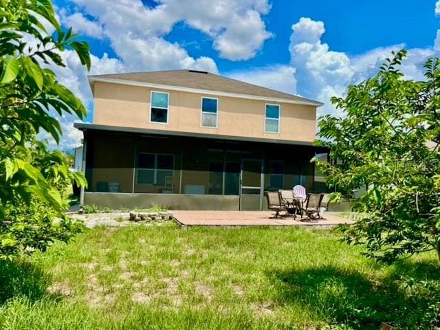 rear view of house with a yard and a patio