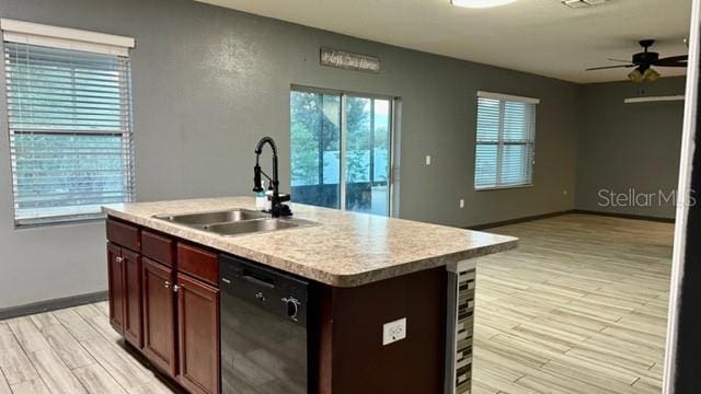 kitchen with sink, dishwasher, a healthy amount of sunlight, and a kitchen island with sink