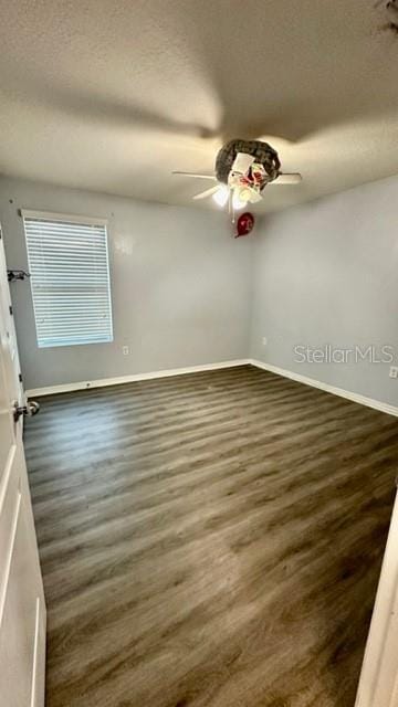 unfurnished room with ceiling fan and dark hardwood / wood-style floors