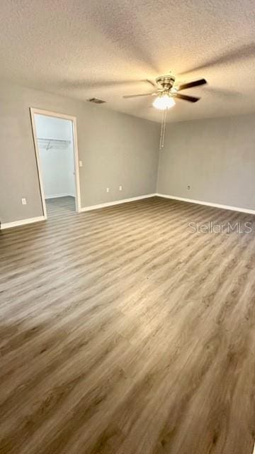 spare room featuring wood-type flooring, a textured ceiling, and ceiling fan