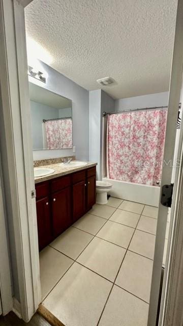 full bathroom featuring toilet, shower / tub combo, a textured ceiling, tile patterned flooring, and vanity