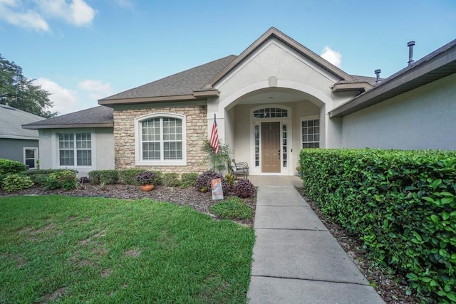 32313 Oak Canopy Dr, Sorrento, FL 32776 - view of front of home featuring stone siding, stucco siding, a shingled roof, and a front yard