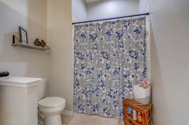 bathroom with a shower with shower curtain and toilet