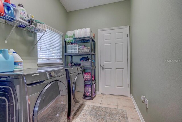 laundry room with washer and dryer and light tile patterned floors