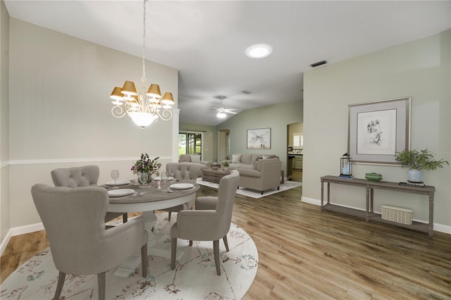 dining space featuring baseboards, ceiling fan with notable chandelier, and wood finished floors