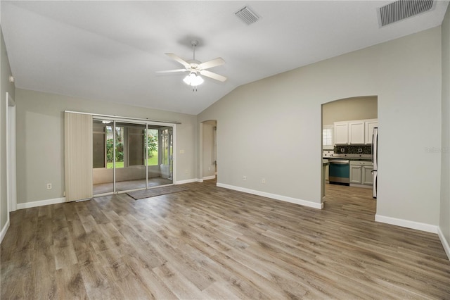 empty room with ceiling fan, lofted ceiling, and light hardwood / wood-style flooring