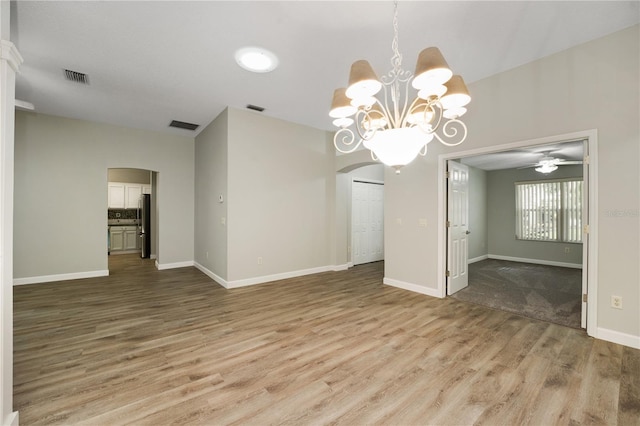 interior space featuring arched walkways, wood finished floors, and visible vents