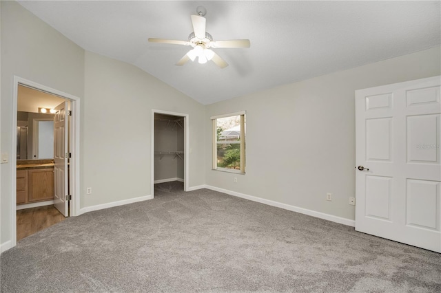 unfurnished bedroom with vaulted ceiling, light carpet, ensuite bathroom, and ceiling fan