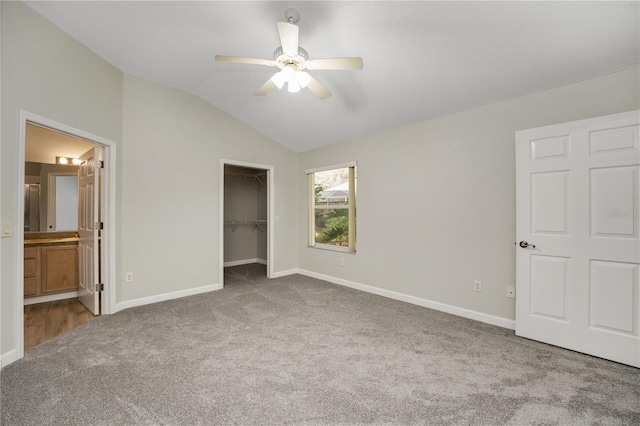unfurnished bedroom featuring baseboards, carpet flooring, and lofted ceiling