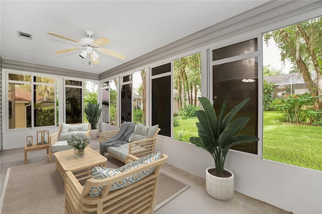 sunroom with visible vents, a ceiling fan, and an outdoor living space