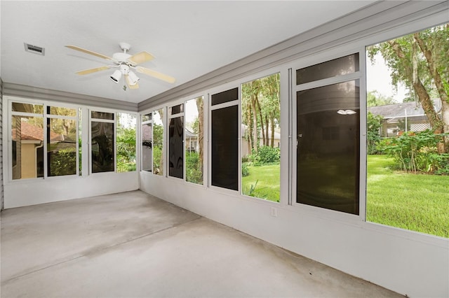 unfurnished sunroom with visible vents, plenty of natural light, ceiling fan, and concrete flooring