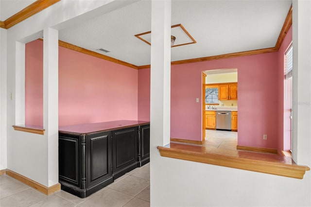 kitchen with light tile patterned floors, crown molding, and dishwasher