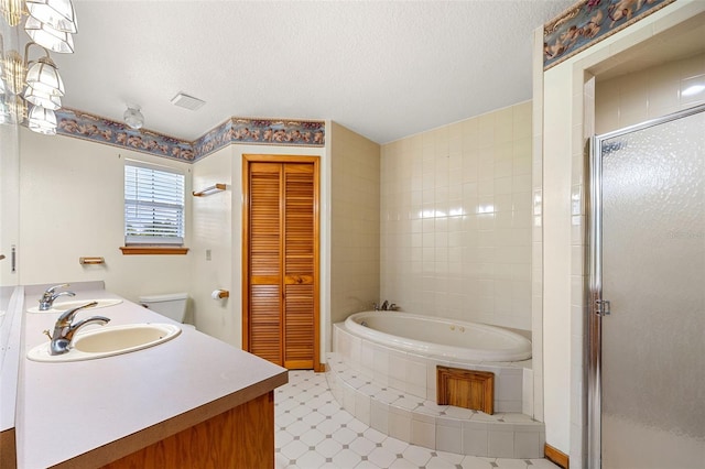 bathroom featuring vanity, a textured ceiling, and separate shower and tub