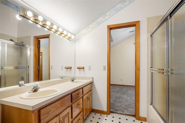 bathroom featuring bath / shower combo with glass door, vanity, vaulted ceiling, and a textured ceiling