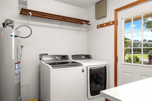 clothes washing area with water heater and washer and dryer