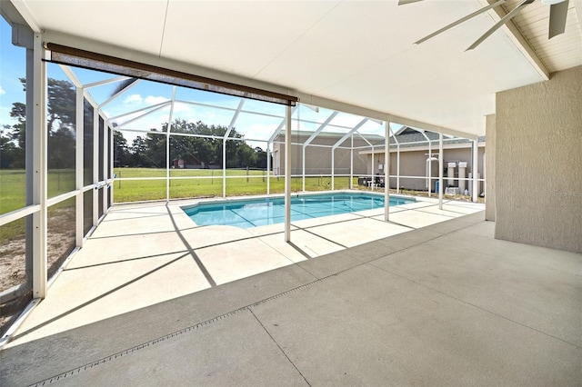 view of swimming pool featuring a lanai, a patio area, and a lawn