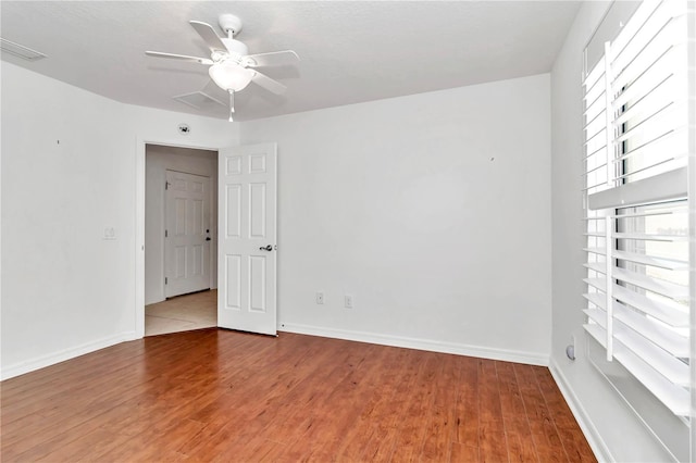 unfurnished room with hardwood / wood-style floors and ceiling fan