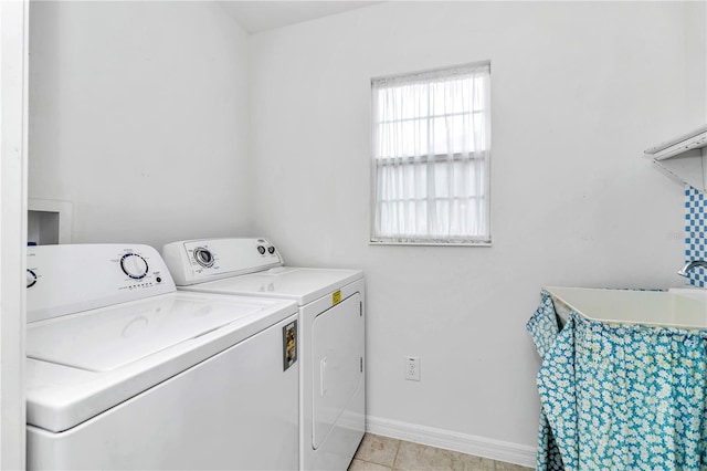 clothes washing area featuring light tile patterned floors, sink, and separate washer and dryer