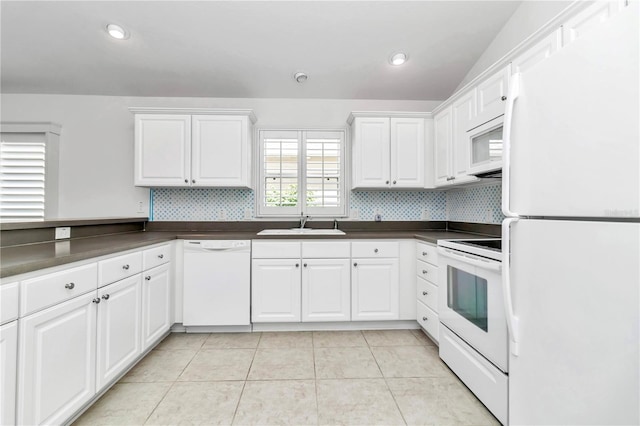 kitchen with white cabinets, white appliances, light tile patterned floors, and decorative backsplash