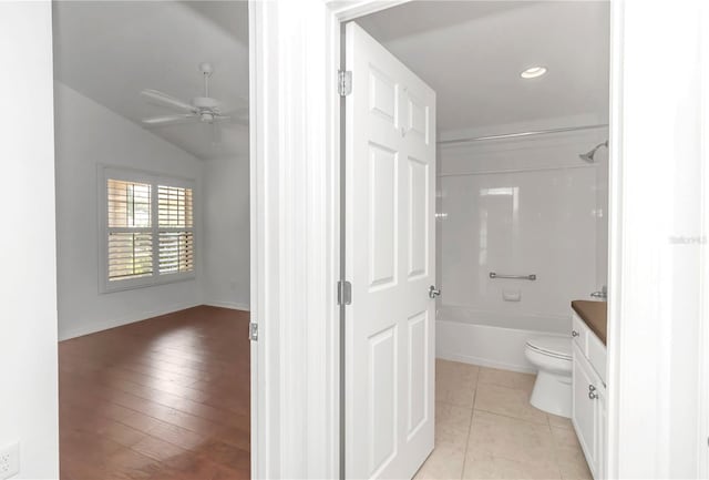 full bathroom featuring toilet, shower / washtub combination, vanity, ceiling fan, and vaulted ceiling