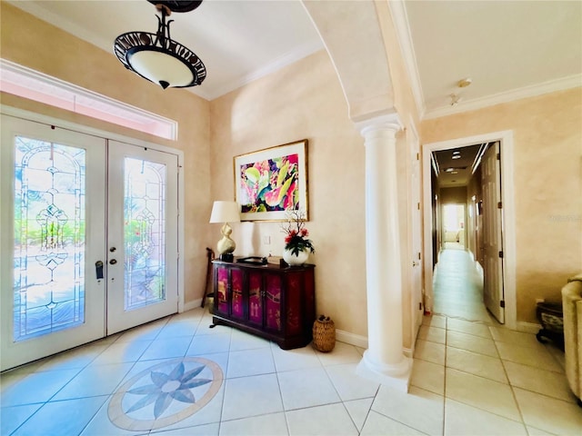 tiled entrance foyer with decorative columns, ornamental molding, and french doors